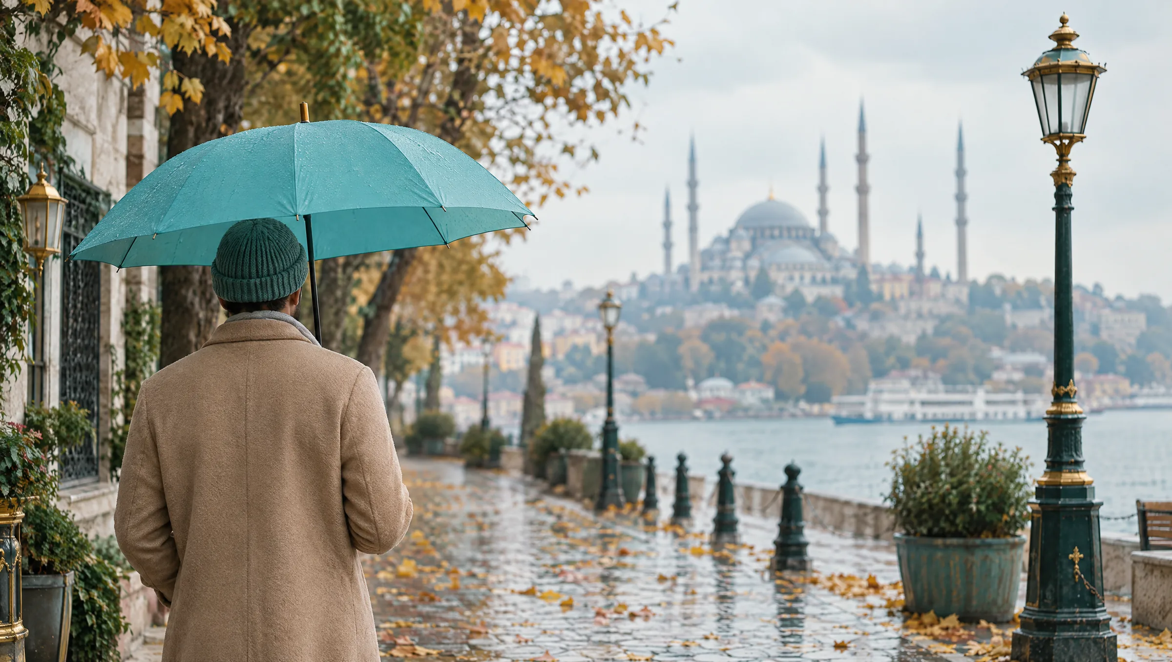 Homme vu de dos, bonnet ample et parapluie turquoise, dans une rue d'Istanbul un jour d'automne