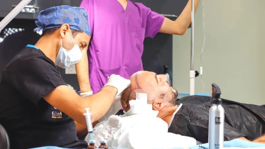 Pendant l'intervention de greffe de cheveux, deux membres de l'équipe Klineva auprès du patient